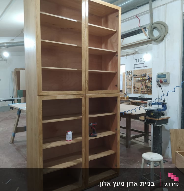 ארון עץ גבוה עם מדפים בסדנת נגרות